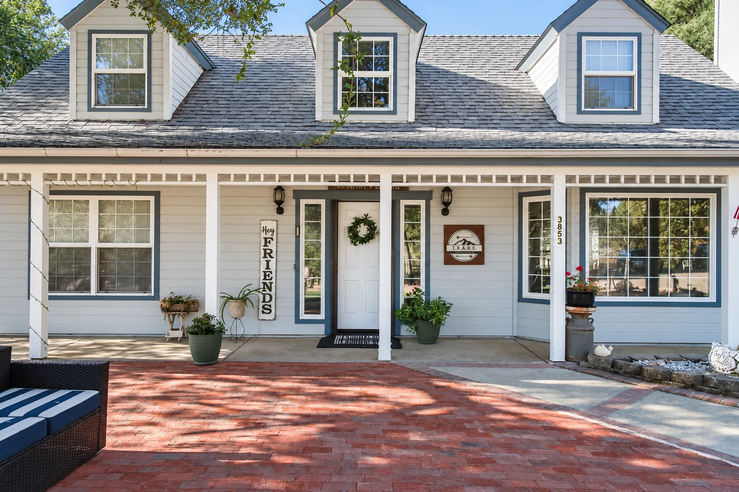 TRADE house at 3853 with a welcoming porch and brick courtyard.